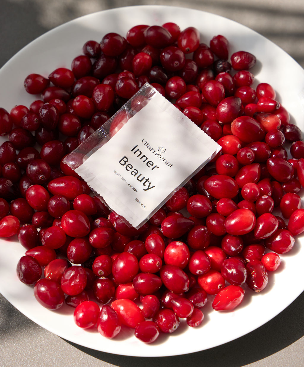 White plate with red berries and a 'Inner Beauty' sachet product packaging.