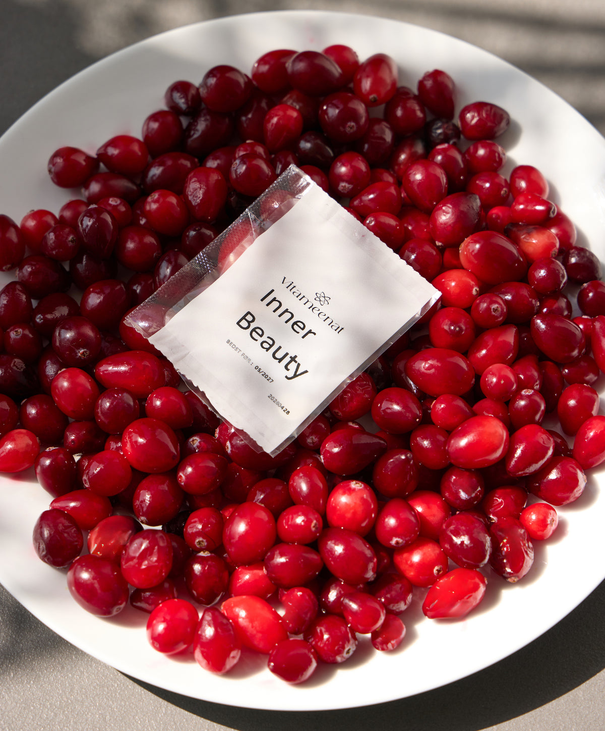 White plate with red berries and a 'Inner Beauty' sachet product packaging.